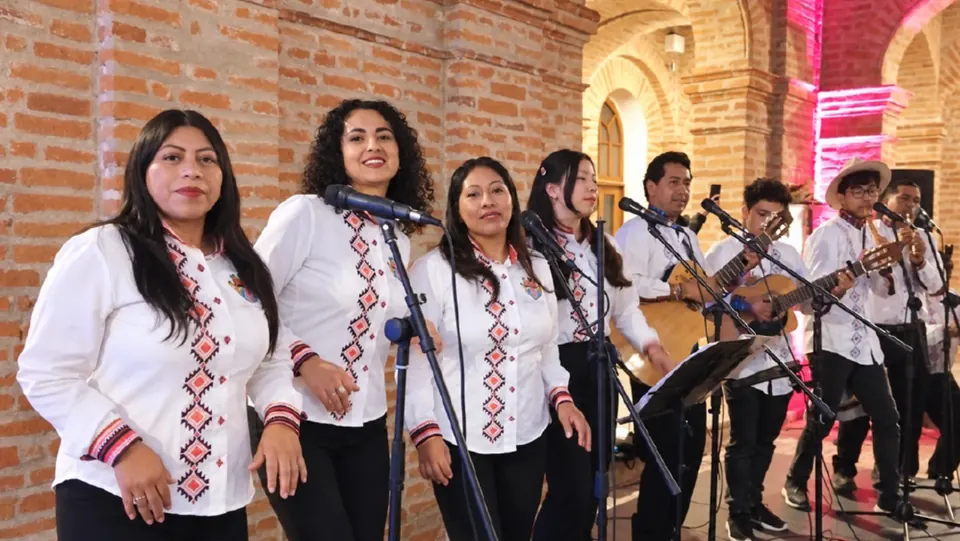 Integrantes de la Agrupación Musical Chávez o no Chávez cantando en escenario con sus camisas bordadas